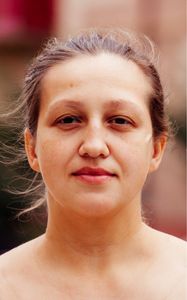 A woman with brown hair and a bare chest.